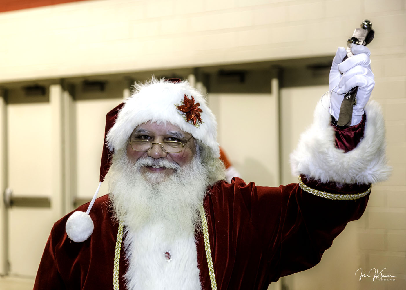 Santa Claus smiling and ringing a bell during a North Pole event